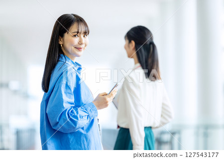 經營一部智能手機的女商人在辦公室 127543177