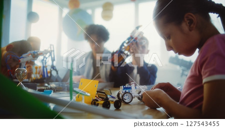 Diverse Group of Children and Young Teacher Working Together on STEM Projects in Multicultural Classroom 127543455