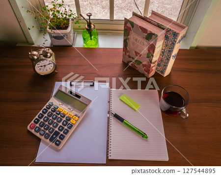 Calculator, notebook, binder, houseplant, drink, old books 127544895