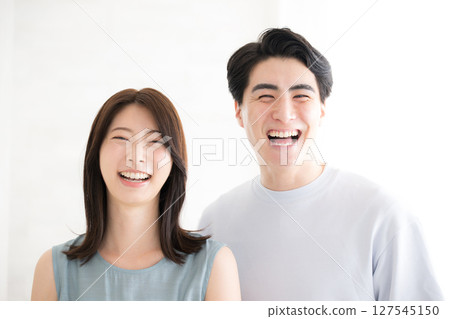 一對身著夏裝的夫婦的特寫鏡頭,白色背景中,他們面帶微笑,看著鏡頭 一對身著夏裝的夫婦的特寫鏡頭,白色背景中,他們面帶微笑,看著鏡頭 127545150