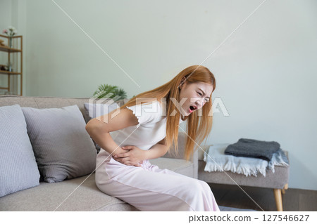 asian woman suffering from stomach ache, undergoing belly pain and discomfort, suffer from menstruation 127546627