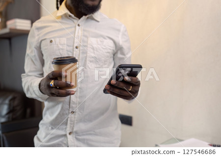 African American business man working with document and laptop while talking on mobile at home on couch. work from home concept African American business man working with document and laptop while talking on mobile at home on couch. work from home concept 127546686