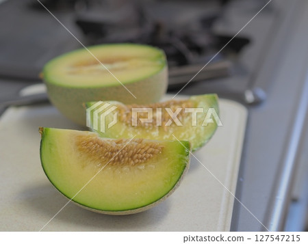 Melon being cut in the kitchen Melon being cut in the kitchen 127547215