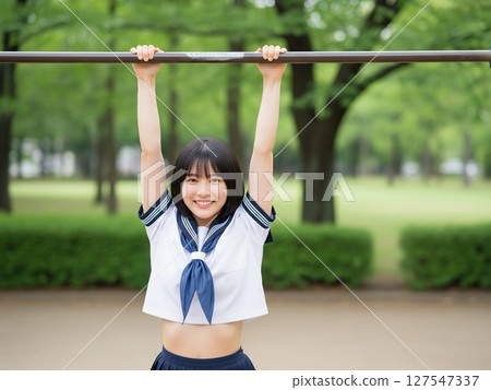 A black-haired, pure-looking idol playing on the horizontal bar in the park 127547337