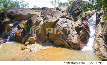Small Rocky Waterfall Flowing into Shallow Pond in Tropical Forest Small Rocky Waterfall Flowing into Shallow Pond in Tropical Forest 127547945