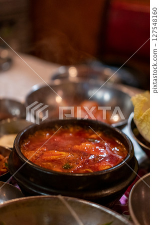 Kimchi Soup served in a bowl, with Korean side dishes served on the table Kimchi Soup served in a bowl, with Korean side dishes served on the table 127548160