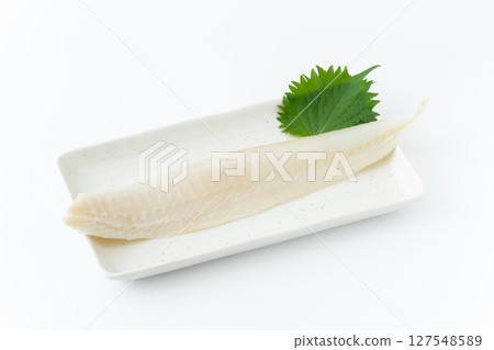 A fence of solefish on a square plate on a white background 127548589