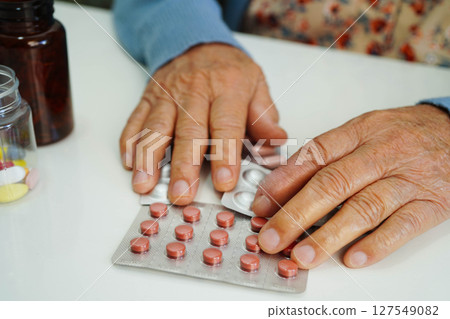 Asian elderly woman holding pill drug in hand, strong healthy medical. Asian elderly woman holding pill drug in hand, strong healthy medical. 127549082