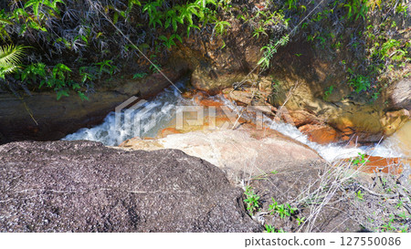 Weathered Granite Boulders and Amber Stream Pools with Lush Greenery 127550086