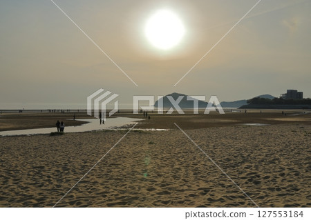 A view of the sandy beach of Mitoyo Chichibugahama Beach with the big sun shining 127553184