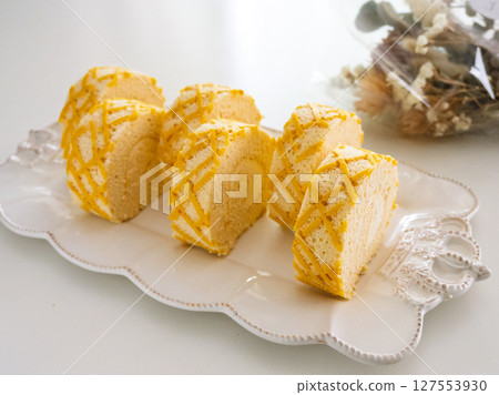 起司捲蛋糕，白色盤子，人造花 127553930