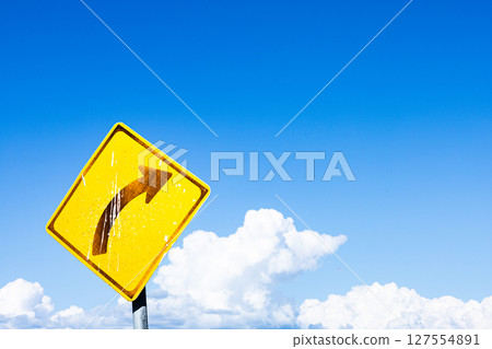 一個簡單的風景，有藍天、白雲和右彎標誌 127554891