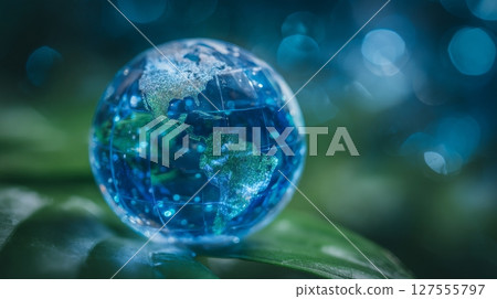 On World Environment Day, a crystal glass world globe on a lush green leaf serves as a symbol of environmental conservation, global business initiatives, and the preservation of nature and ecology 127555797