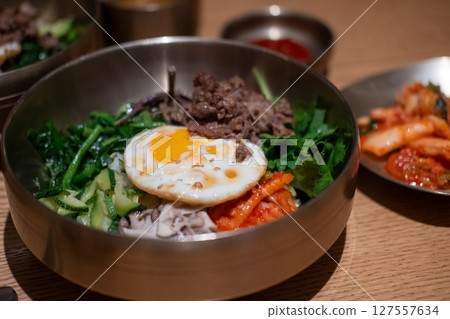 Bibimbap, a Korean rice dish. It is cooked rice mixed with namul, gochujang, egg and meat. 127557634