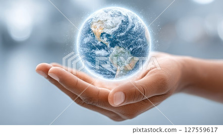Glowing Earth in Hand on Blue Background Glowing Earth in Hand on Blue Background 127559617