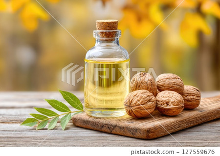 Walnut Oil Bottle with Walnuts on Wooden Board Walnut Oil Bottle with Walnuts on Wooden Board 127559676