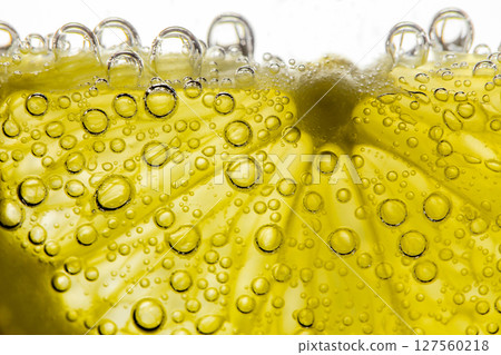 Lemon sliced in water with air spherical bubbles, in background light, close-up selective focus Lemon sliced in water with air spherical bubbles, in background light, close-up selective focus 127560218