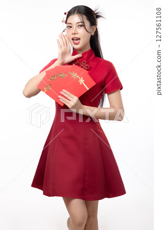Portrait of joyful beauty Asian woman in red Cheongsam Chinese traditional dress celebrating with lucky red envelopes on Chinese New Year festival isolated on white background. 127561108
