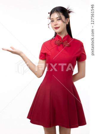 Portrait of joyful beauty Asian woman in red Cheongsam Chinese traditional dress celebrating and open her palm for announcing isolated on white background. 127561546
