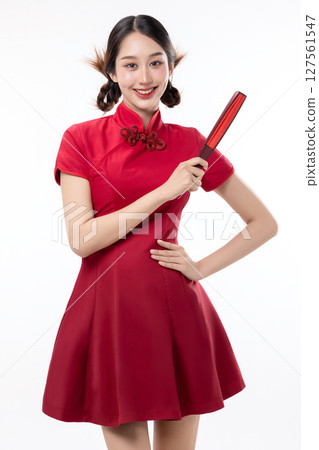 Portrait of joyful beauty Asian woman in red Cheongsam Chinese traditional dress pointing red fan for Chinese New Year festival content. 127561547