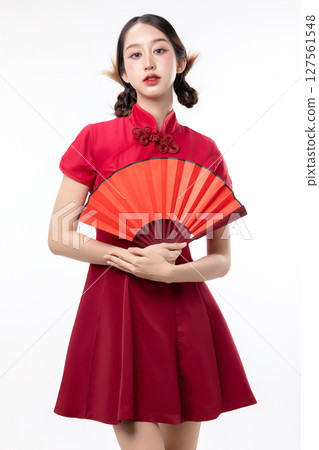 Portrait of joyful beauty Asian woman in red Cheongsam Chinese traditional dress holding red fan isolated on white background for Chinese New Year festival content. 127561548