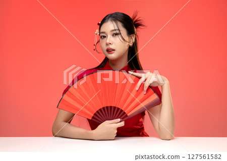 Portrait of beauty Asian woman in red Cheongsam Chinese traditional dress isolated on red background. 127561582