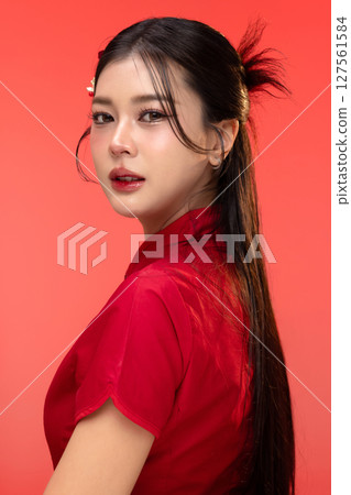 Portrait of beauty Asian woman in red Cheongsam Chinese traditional dress isolated on red background. 127561584