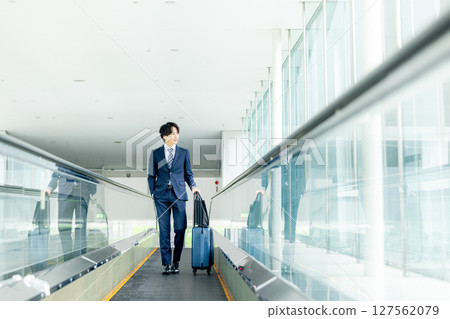 A young man walking with a carry bag 127562079