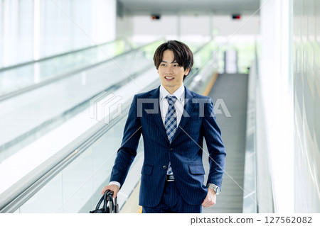 A young man walking with a carry bag 127562082