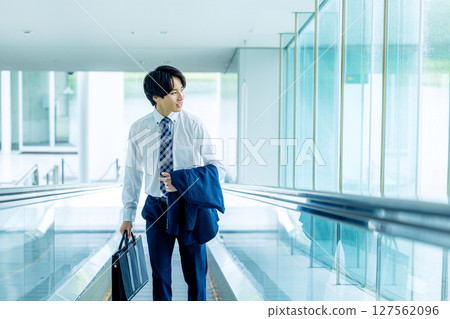 A young man walking with a carry bag 127562096