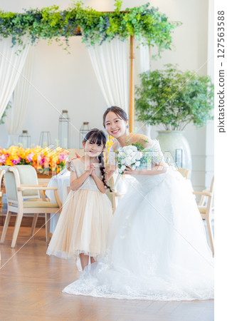 Bride and child in wedding dress Bride and child in wedding dress 127563588