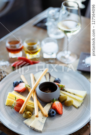 Cheese platter for two: Goat cheese cream, gorgonzola, camembert, grissini and fig jam. Delicious healthy Italian traditional food closeup served for lunch in modern gourmet cuisine restaurant Cheese platter for two: Goat cheese cream, gorgonzola, camembert, grissini and fig jam. Delicious healthy Italian traditional food closeup served for lunch in modern gourmet cuisine restaurant 127564096