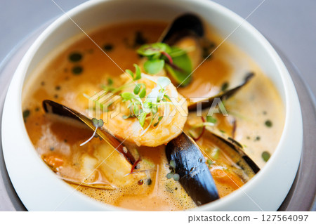 Shrimp Bisque with Seafood. King prawn, blue mussels, cod, whipped cream. Delicious traditional food closeup served for lunch in modern gourmet cuisine restaurant Shrimp Bisque with Seafood. King prawn, blue mussels, cod, whipped cream. Delicious traditional food closeup served for lunch in modern gourmet cuisine restaurant 127564097