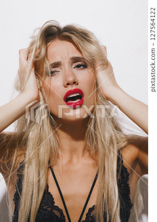 emotions and feelings concept - stunning blonde woman in delicate lingerie, experiencing pure passion, her mouth open, eyes shut, basking in bright studio light against a clean white background emotions and feelings concept - stunning blonde woman in delicate lingerie, experiencing pure passion, her mouth open, eyes shut, basking in bright studio light against a clean white background 127564122