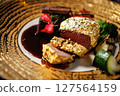 Luxurious gold-plated beef steak accompanied by grilled zucchini, cherry tomatoes, and broccoli. Finished with a rich sauce and edible flowers, presented on a stylish plate in a high-end restaurant 127564159
