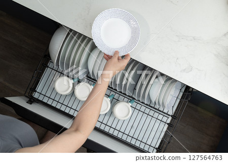 Organizing Clean Dishes in a Modern Kitchen Drawer With a Sleek Design and Efficient Layout Organizing Clean Dishes in a Modern Kitchen Drawer With a Sleek Design and Efficient Layout 127564763