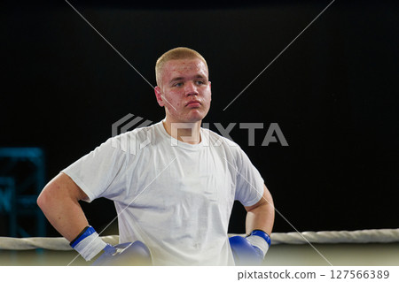 A focused boxer exudes intensity as they await the start of their bout. 127566389