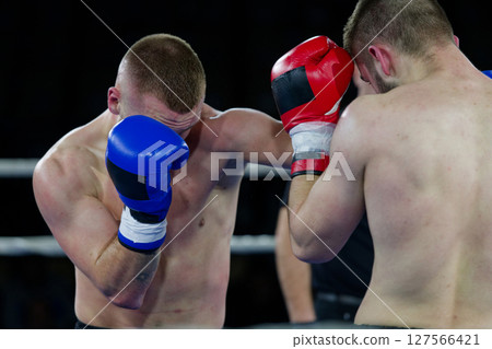 Fierce boxing match showcases athletes' power and skill. 127566421