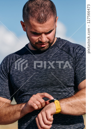 Athletic Man Checking Running Results on Smartwatch Athletic Man Checking Running Results on Smartwatch 127566473