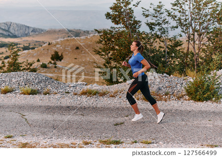 Empowered Runner Embracing Nature's Beauty on a Serene Morning Trail. Empowered Runner Embracing Nature's Beauty on a Serene Morning Trail. 127566499