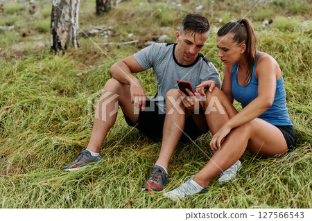 Romantic Couple Planning New Running Routes in the Forest with Smartphone Romantic Couple Planning New Running Routes in the Forest with Smartphone 127566543
