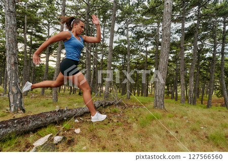 Fearless Woman Conquering Wooden Obstacles in the Dangerous Forest Terrain. 127566560