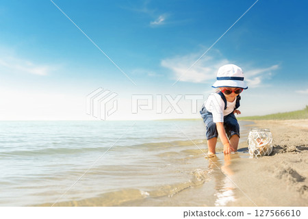 Kid play on the beach on a hot sunny day Kid play on the beach on a hot sunny day 127566610