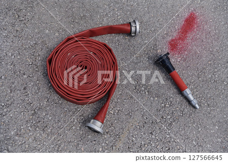 Coiled Fire Hose Ready for Action on the Ground 127566645
