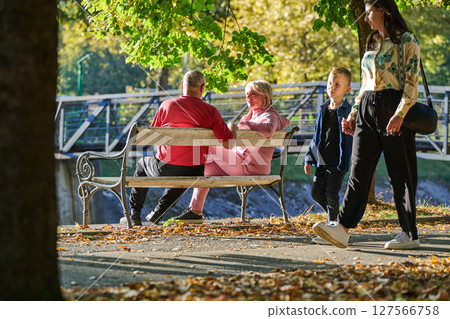 Elderly couple finding solace and joy as they rest on a park bench, engaged in heartfelt conversation, following a rejuvenating strol a testament to the enduring companionship and serene connection 127566758