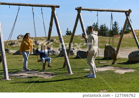 A modern family, along with their son, revels in the joy of a muddy day in nature, running and playing together, encapsulating the beauty of a healthy and active lifestyle 127566762