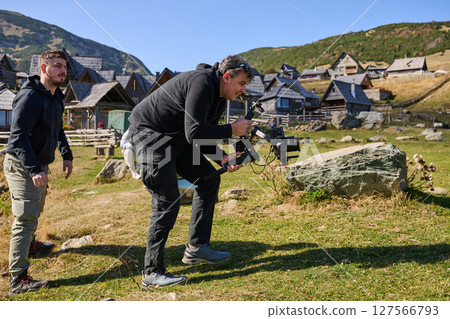 A skilled videographer, equipped with professional gear, captures the essence of nature's beauty, expertly documenting the scenic landscape in a cinematic masterpiece that reflects the seamless blend 127566793