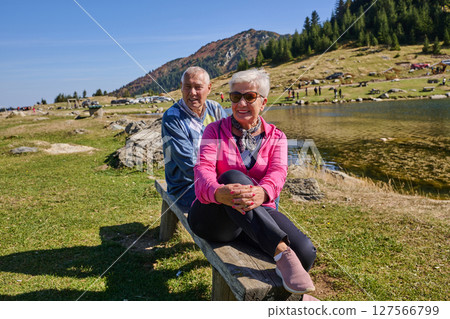 Elderly couple finding solace and joy as they rest on a park bench, engaged in heartfelt conversation, following a rejuvenating strol a testament to the enduring companionship and serene connection 127566799