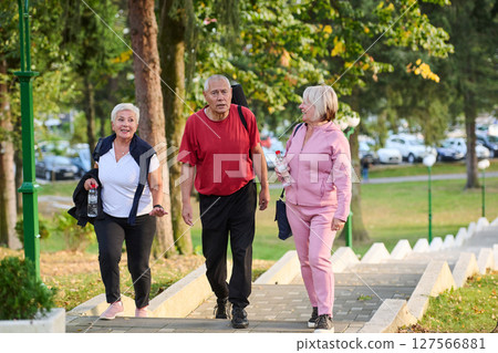 A group of senior friends takes a well-deserved break in nature, fostering not only fitness but also camaraderie and a shared commitment to maintaining a healthy and active lifestyle in their golden 127566881