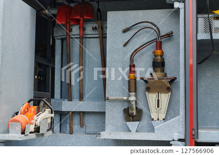 Close-up of essential firefighting equipment on a modern firetruck, showcasing tools and gear ready for emergency response to hazardous fire situations Close-up of essential firefighting equipment on a modern firetruck, showcasing tools and gear ready for emergency response to hazardous fire situations 127566906